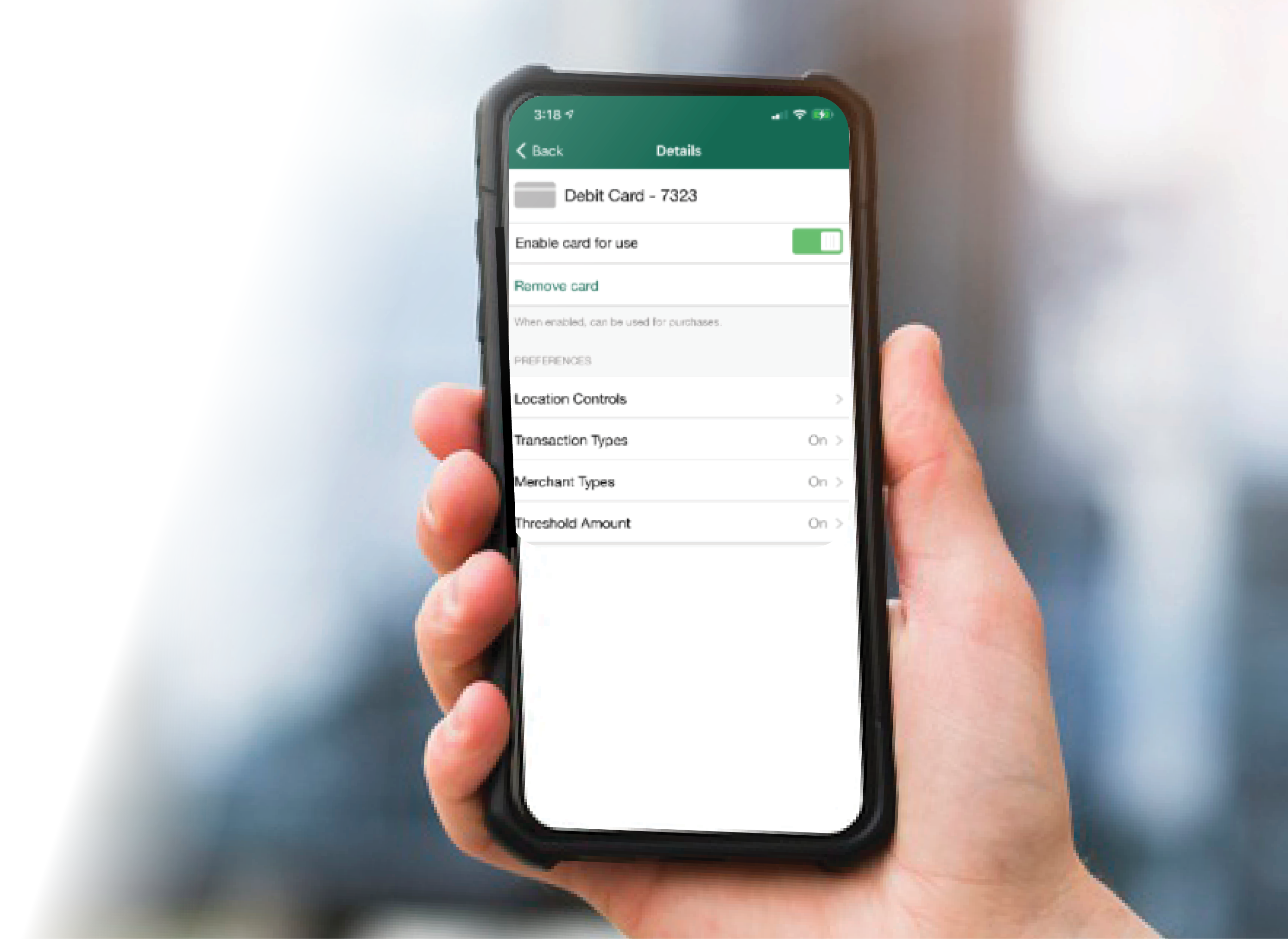 Close-up of a hand holding a mobile phone accessing card controls via the First Community Bank app.