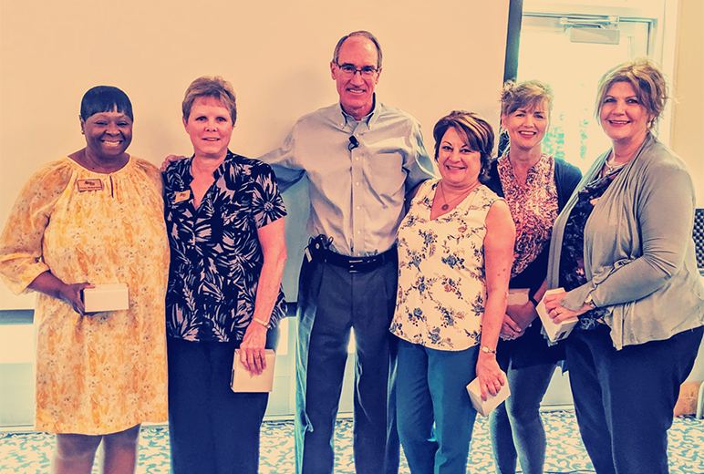 Bank president, Mike Crapps, smiling and posing with several FCB employees.