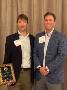 Vaughan Dozier holding his award next to Drew Painter